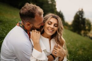 Young couple deeply in love laughing and cuddling, enjoying the time spent in nature