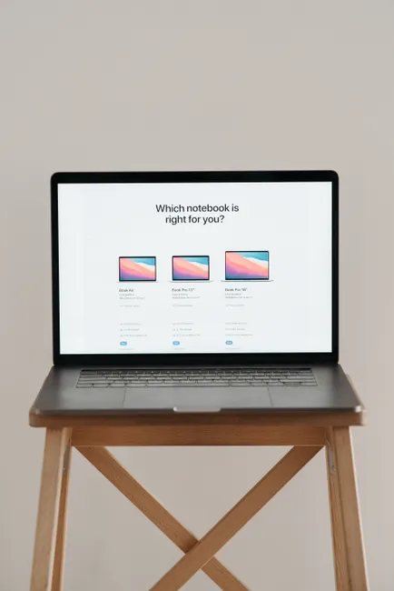 Laptop on a wooden stand with screen showing notebook comparison.
