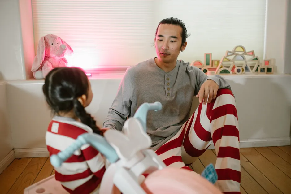 A father and daughter enjoy quality time in a cozy home, engaging in playful conversation.