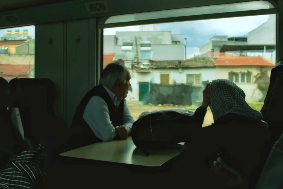 An elderly couple looking out the window during a train journey, capturing a moment of reflection.
