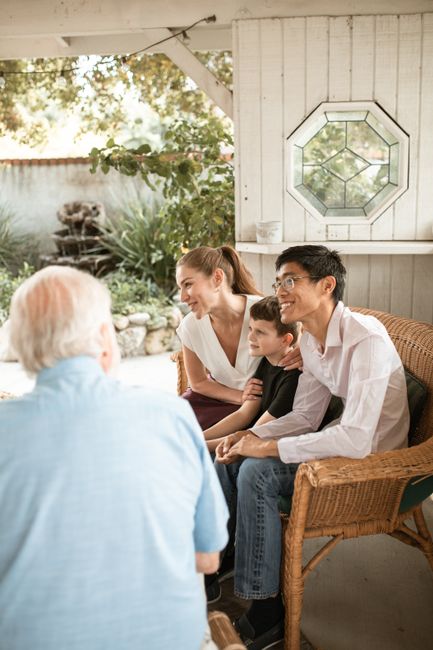 Diverse family bonding in a bright living room, sharing smiles and conversation.