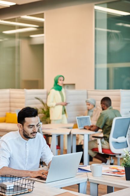 Professional team working in a modern open-plan office, showcasing diversity and collaboration.