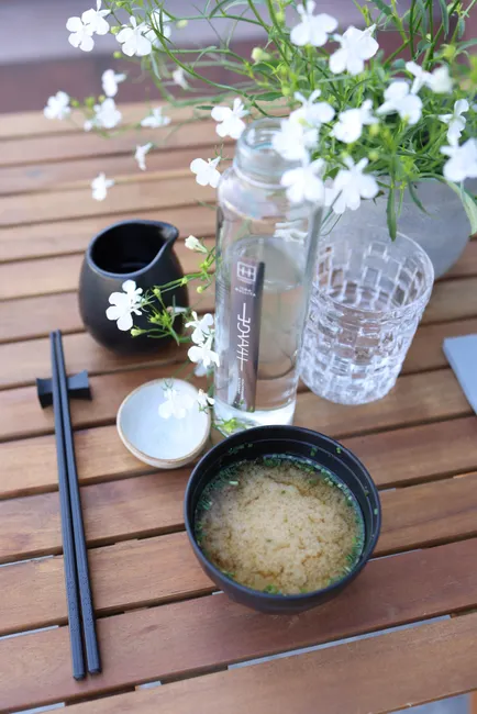 A refreshing miso soup with elegant table setting, perfect for a healthy meal.