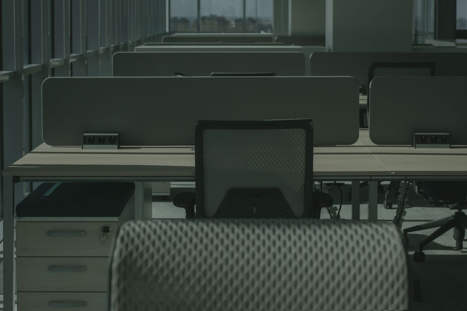 A sleek modern office with multiple desks and chairs, showcasing an empty and orderly workspace.