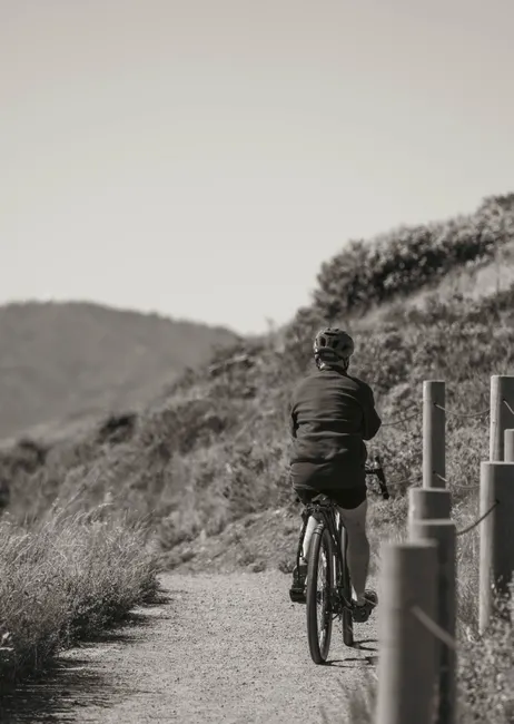 Cyclist riding along a scenic mountain trail, embracing the outdoors and leisurely adventure.