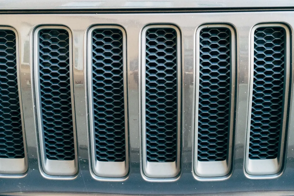 Detailed shot of an automobile's silver front grille and radiator.