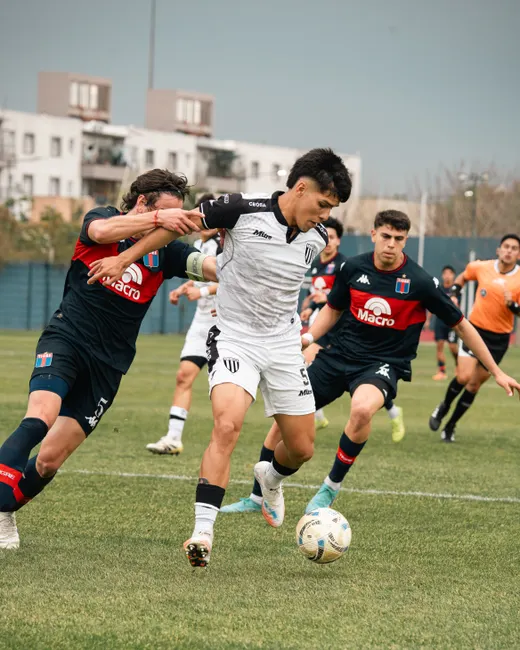 Energetic soccer game with young players competing intensely on a green field.
